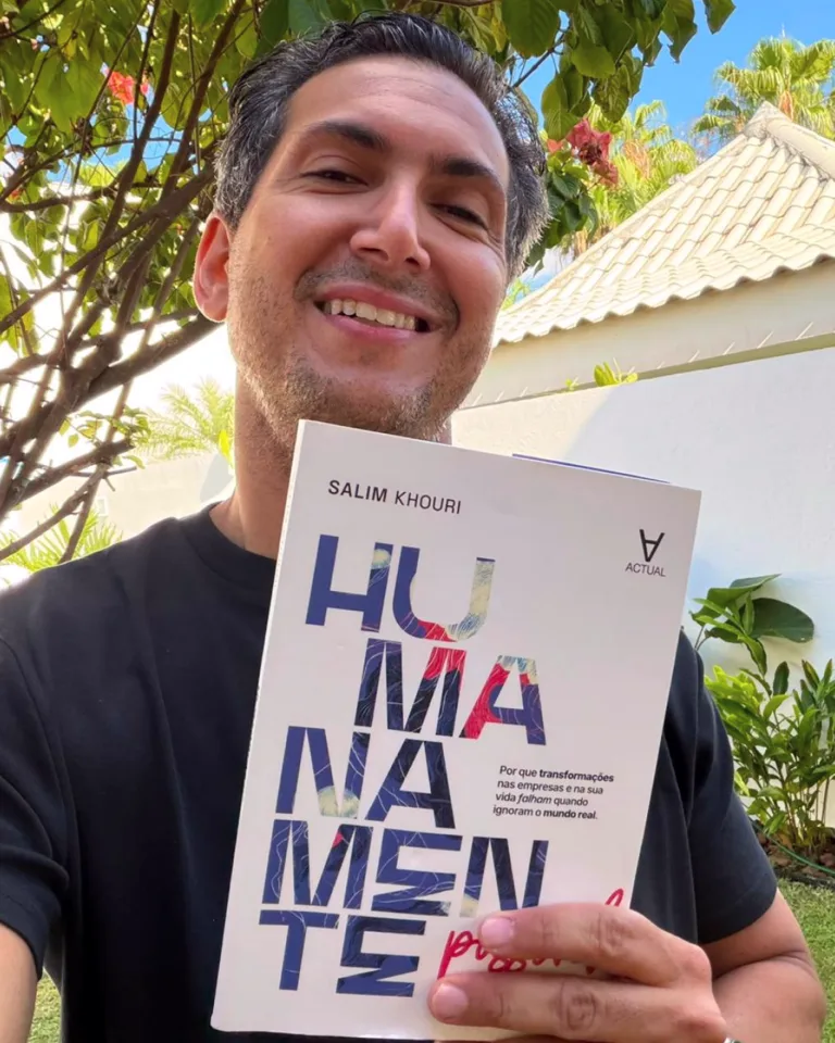 Salim Khouri sorrindo, segurando o livro Humanamente Possível.